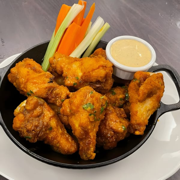 Hilltop Kitchen & Bar's American-style chicken wings with celery, carrots, and dipping sauce.