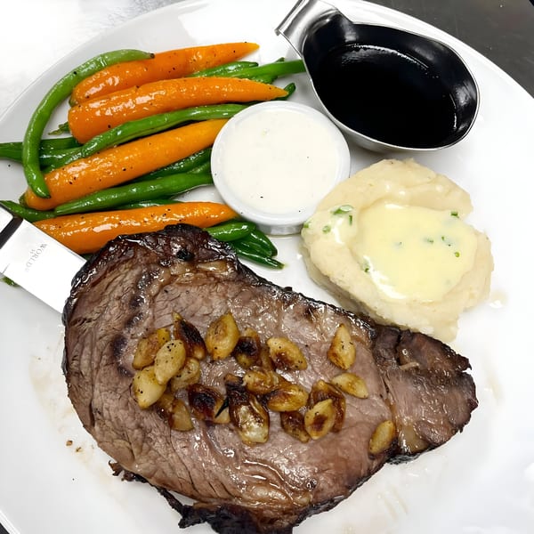 Hilltop Kitchen & Bar's American cuisine: steak with roasted garlic, mashed potatoes, green beans, and carrots.